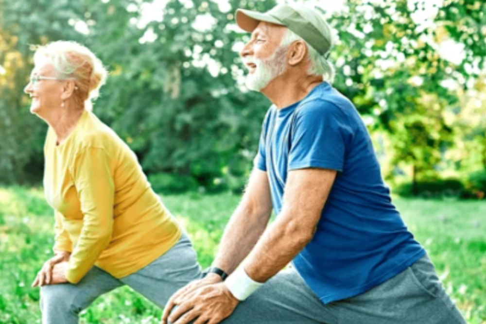 Image of older couple stretching outside.
