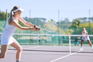 Image of two women playing in a tennis tournament