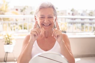 Picture of a senior woman applying anti-aging cream