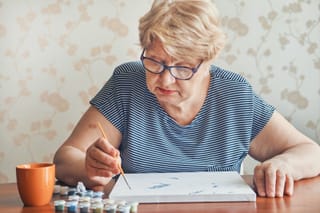 Picture of a senior woman doing paint by numbers