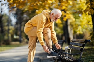 Image of a senior man adjusting his athletic shoes