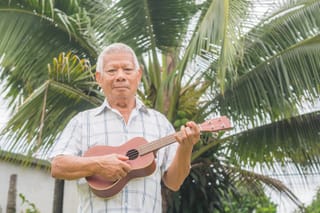 Picture of a senior man playing ukelele