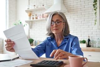 Image of a senior woman calculating mortgage interest