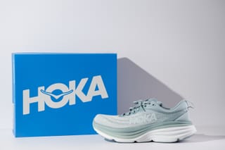 Photo of a Hoka shoe next to the shoe box