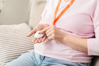 Picture of a senior woman with a medical alert system remote control on a lanyard