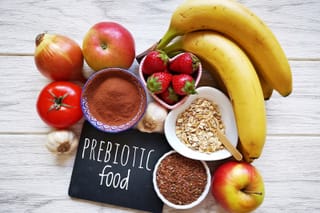 Picture of prebiotic foods including bananas, apples, tomato, onion, garlic, strawberries 