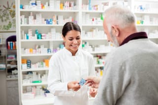 Picture of a senior man at a pharmacy getting prescription drugs from a pharmacist 