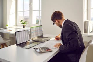 Picture of an auditor with two laptop computers