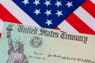 Image of United States Treasury check next to a US flag