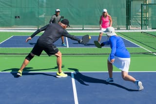 Picture of two senior couples playing pickleball