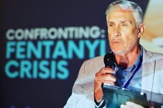 Image of a man at a conference speaking about confronting the fentanyl crisis