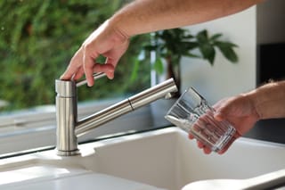 Photo of a man filling up a cup with water