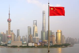Picture of a Chinese flag with Shanghai in the background 