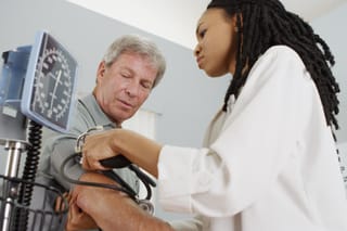 Picture of a senior man having his blood pressure checked by a medical professional 