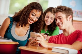 Picture of students in school holding cell phones