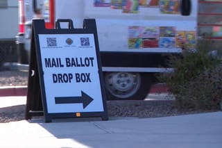 Picture of a sign pointing to a mail ballot drop box.