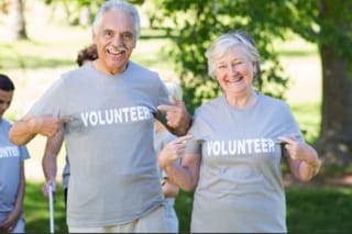 Image of older man and woman with shirts that say volunteer