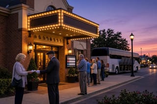 Visitors filing into a lit Branson theater entrance at dusk as a woman hands tickets to an usher.
