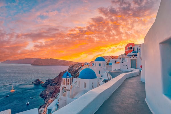 Picture of Santorini Greece, historic houses with blue roofs, and the volcano caldera