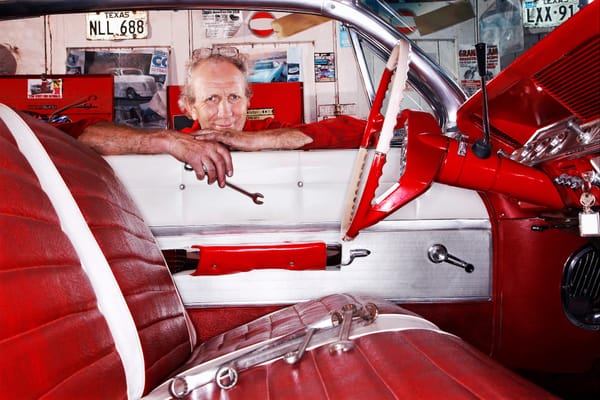 Picture of a senior citizen working on restoration of a classic car