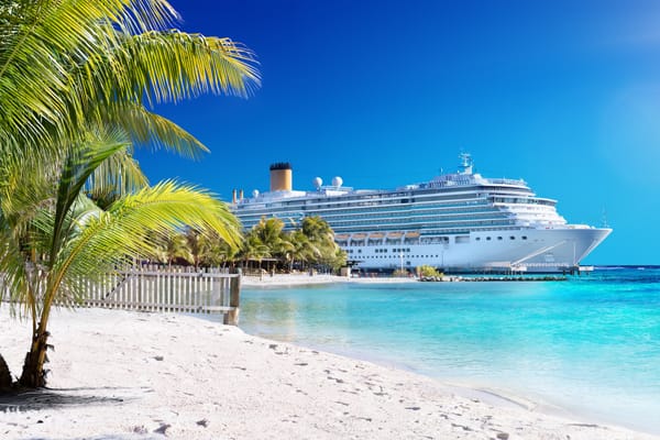 Picture of a cruise ship in the Caribbean docked at a port near the beach 