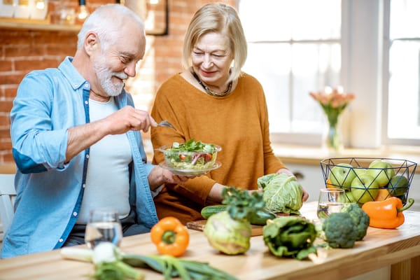 Picture of two senior citizens cooking a healthy meal