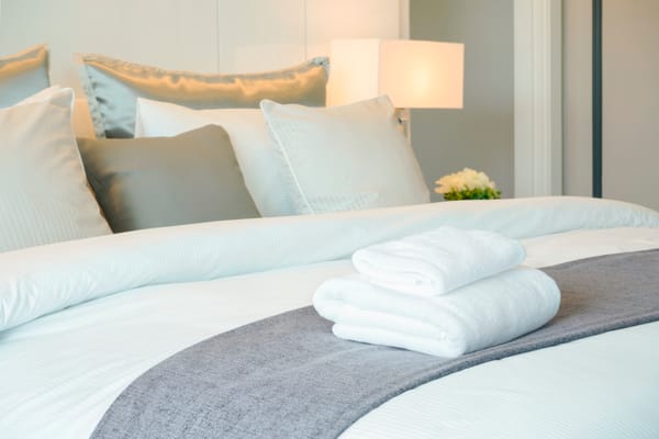 Picture of a hotel bed with nice linens and towels