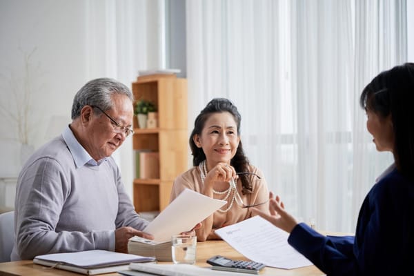 Photo of a senior couple speaking with an advisor regarding estate planning