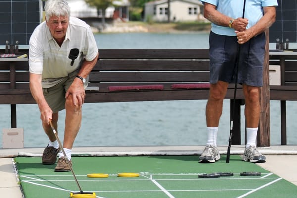 Picture of two seniors playing shuffleboard