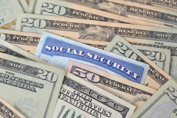 Picture of a social security card alongside 100 dollar bills and 20 dollar bills