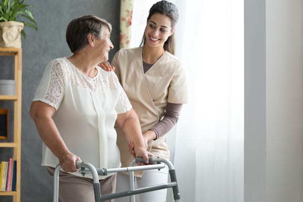 Picture of a senior woman getting assistance with ADLs from a caretaker