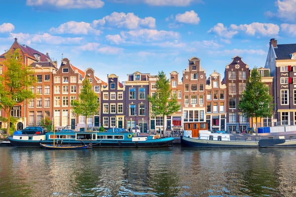 Photo of a row of building and boats on a canal in Amsterdam