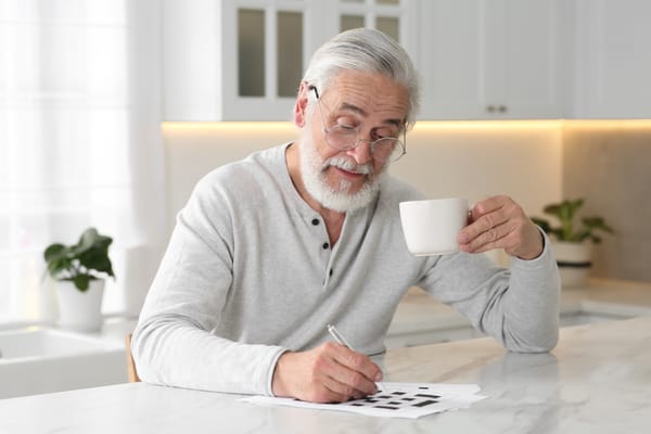 Image of a senior man filling out a crossword puzzle