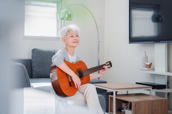 Image of a woman learning to play guitar