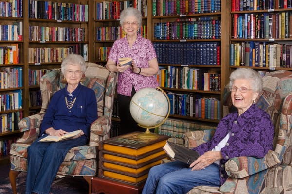 Image of 3 senior women in a library for a book club meeting