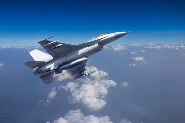 Photo of Fighter jet military aircraft flying over altocumulus cloud with blue sky 