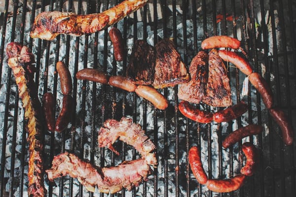 Picture of sausages and brisket being barbecued  