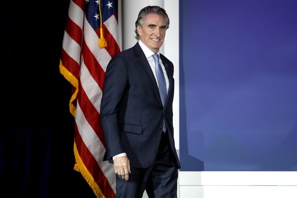 Picture of Doug Burgum and a United States flag