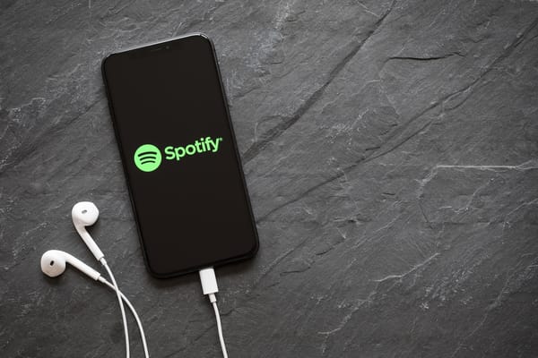 Picture of a smart phone with the Spotify app and earbuds