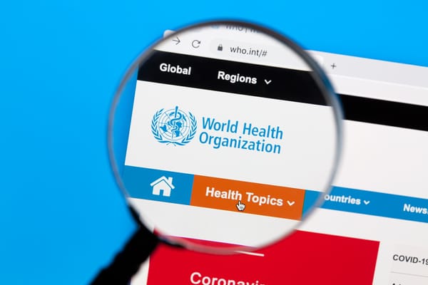 Picture of the World Health Organization website under a magnifying glass