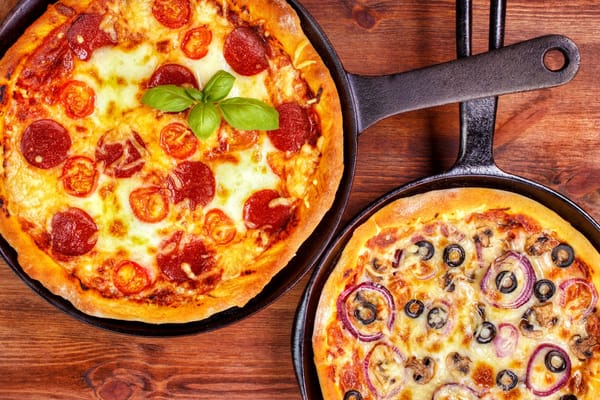 Picture of two homemade pizzas in cast iron skillets 