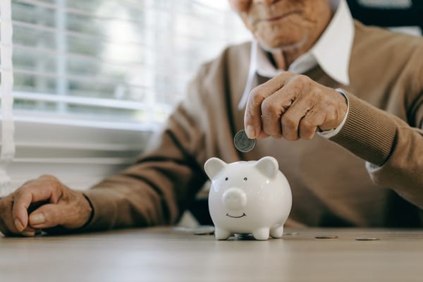 Photo of a man putting a coin in a piggy bank