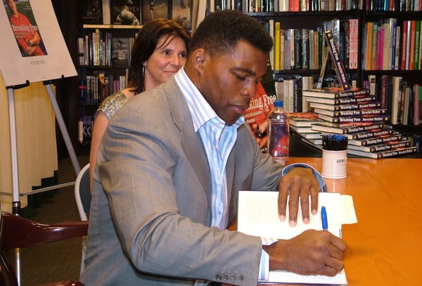 Picture of Herschel Walker signing a book 