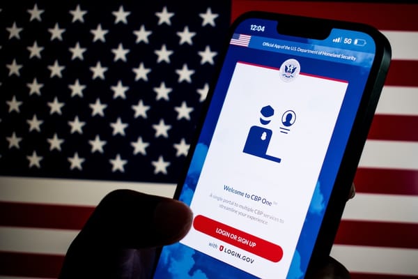 Picture of a smartphone with the CBP One app and an American flag in the background