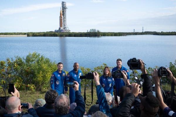 Picture of the Artemis II crew with Artemis II on the launchpad in the background