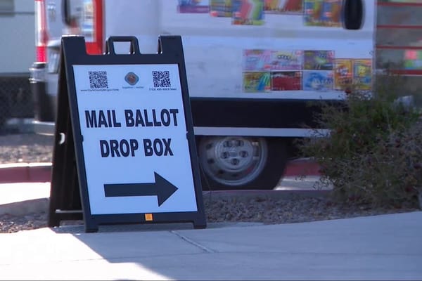 Picture of a sign pointing to a mail ballot drop box.